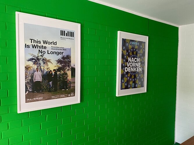 Grüne Wand mit zwei gerahmten Postern