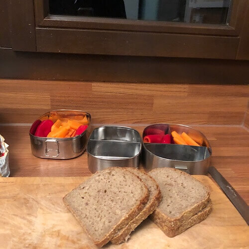 Brot und Frühstücksdosen auf Holzbrett