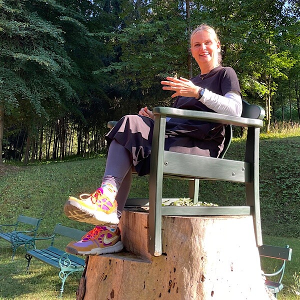 Frau auf Stuhl sitzend auf Baumstamm