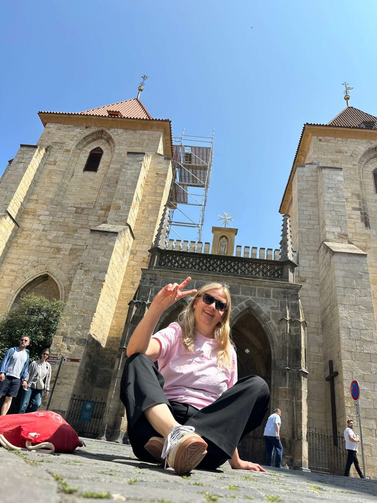 Frau sitzt vor Tor im Schneidersitz