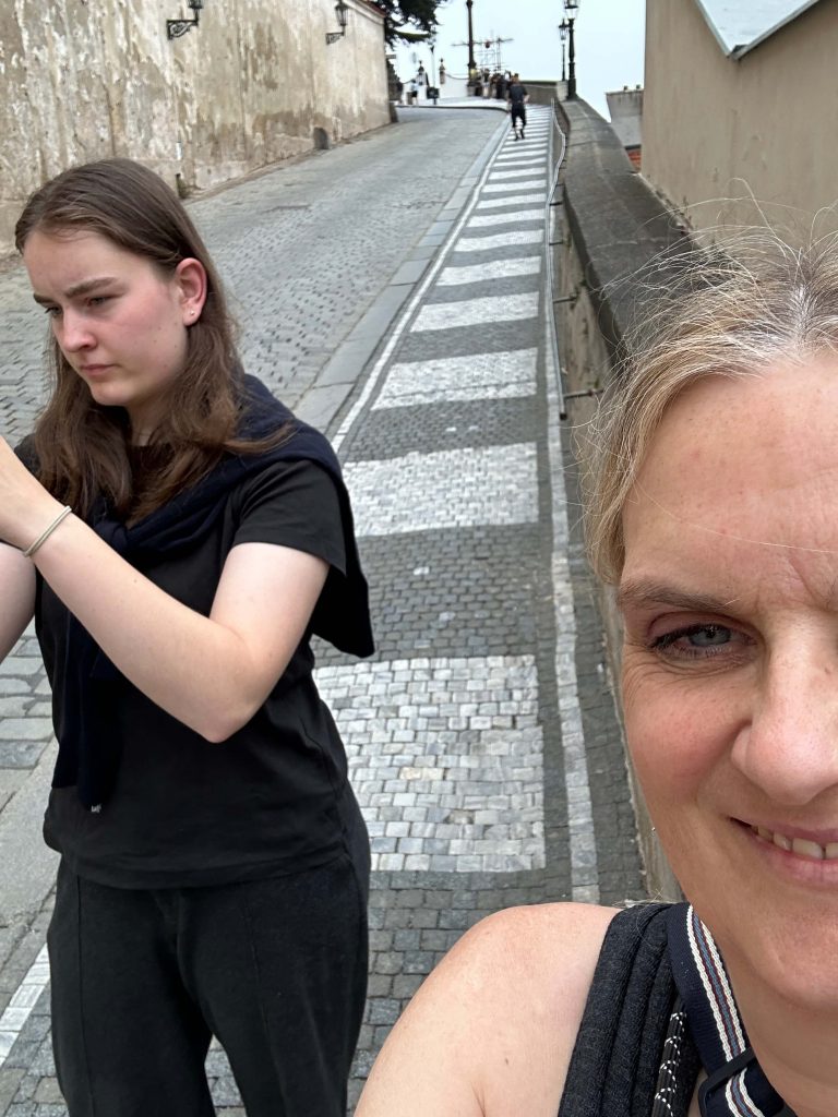 Zwei Frauen stehen an einer Straße und machen Selfies