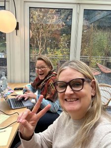 Zwei Frauen sitzen am Tisch und arbeiten zusammen