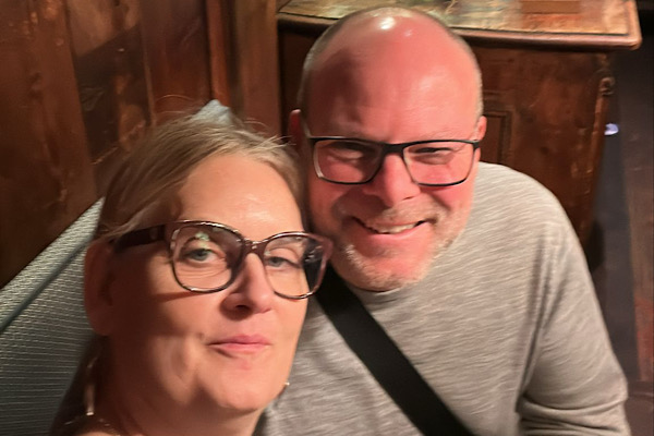 Mann und Frau lächeln in die Kamera.