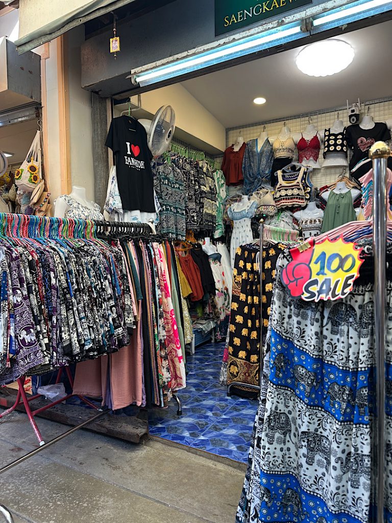 In einem Bekleidungsgeschäft sind zwei Ständer zu sehen. Auf den Ständern sind Stoffhosen mit aufgedrucktem Elefantenmuster.