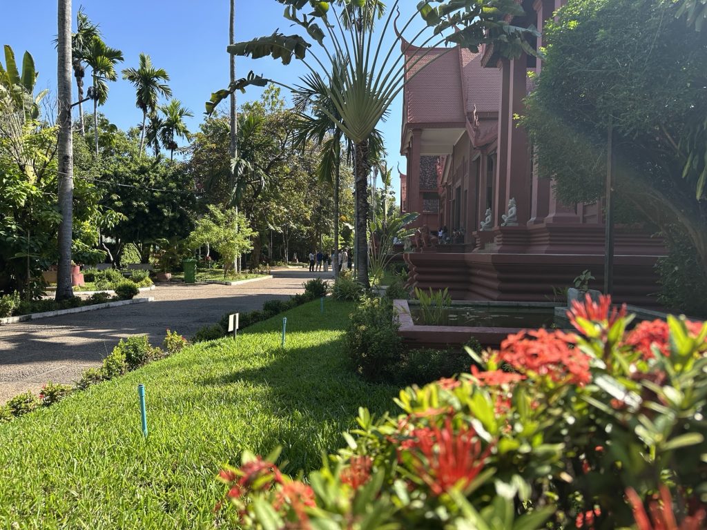 Auf dem Bild ist das Nationalmuseum für Kunst in Phnom Penh zu sehen. Es ist rot und davor grüner Rasen.