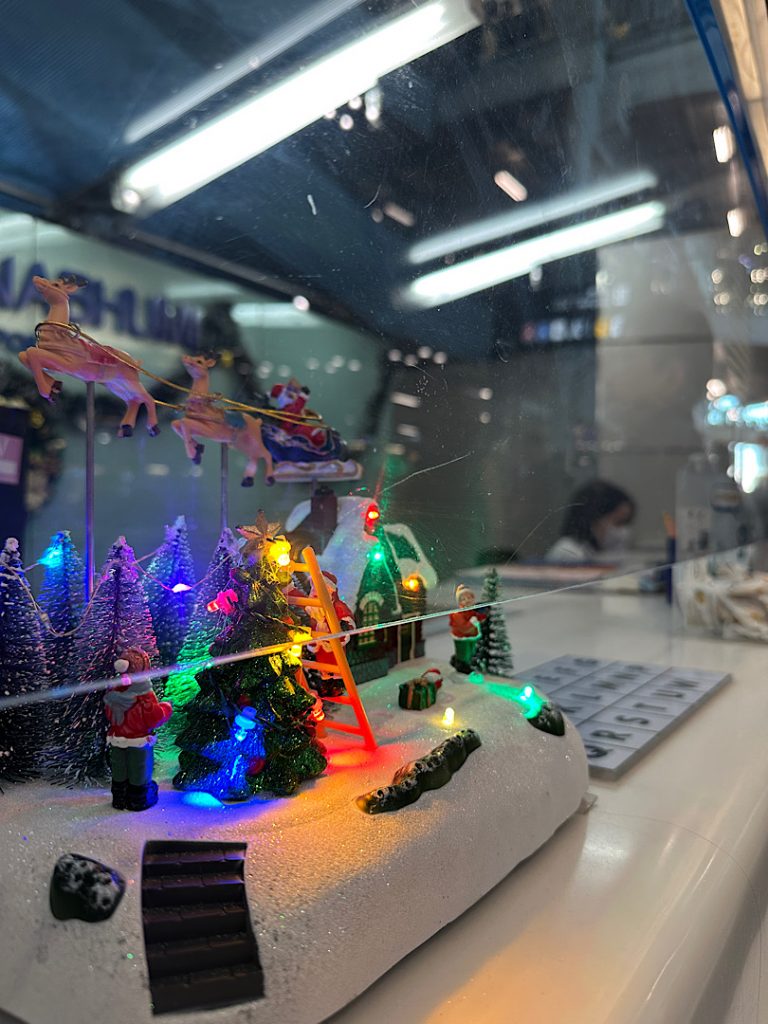 Am Tresen eines Flughafenschalters in Bangkok steht eine Winterlandschaft mit Lichteffekten.