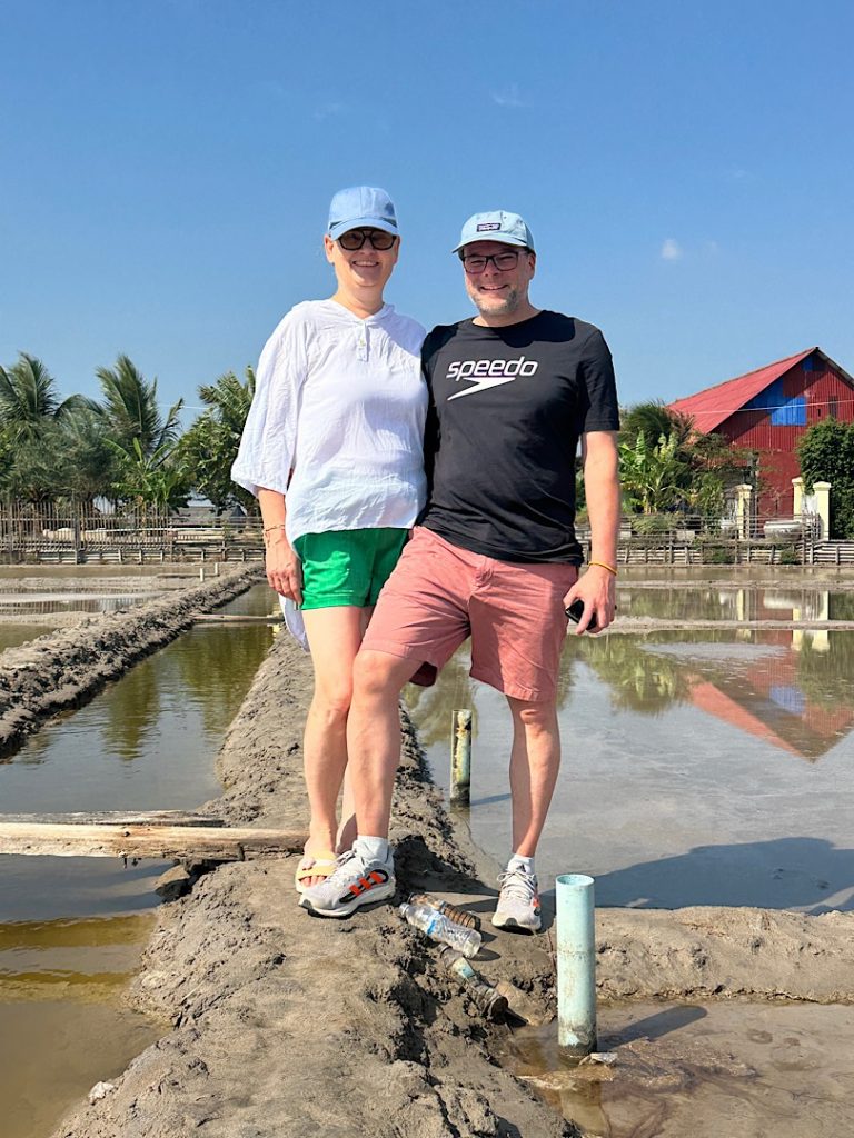 Ein Mann und eine Frau posieren vor einem Salzfeld in Kambodscha, Kampot