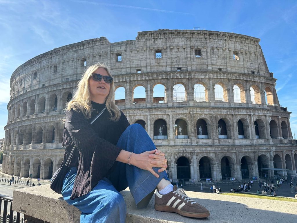 Frau mit Sonnenbrille vor dem Coloseum in Rom